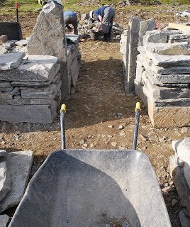 Showing the narrow straight entrance into the broch, with tall door uprights, seen from the vantage point of a dusty wheelbarrow.