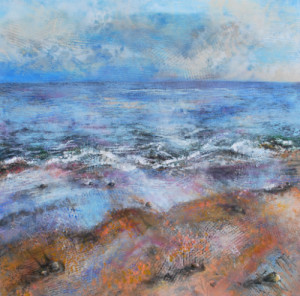 A square seascape painting in mixed media. A mid-blue sky with loose grey clouds sits over a calm mid-blue sea with gently lapping water, small waves, and In the foreground is a sandy shore in oranges and beiges, scattered with impressionistic seaweed. The style is loose, with extensive use of texture, painterly marks, spray painted stencilled and printed textures (such as grid work, net curtain fabric florals, strips), but the effect is cohesive and not overly busy.