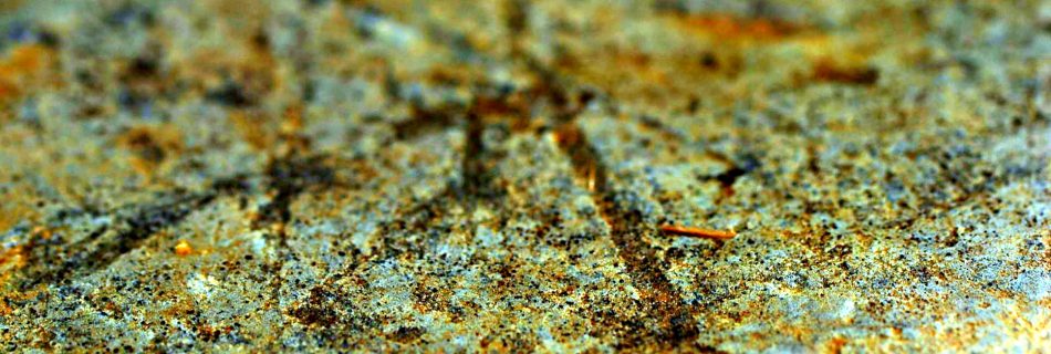 A macro photo showing the man made carved straight lines, running at different angles, in the surface of sandstone found at an archaeological dig.